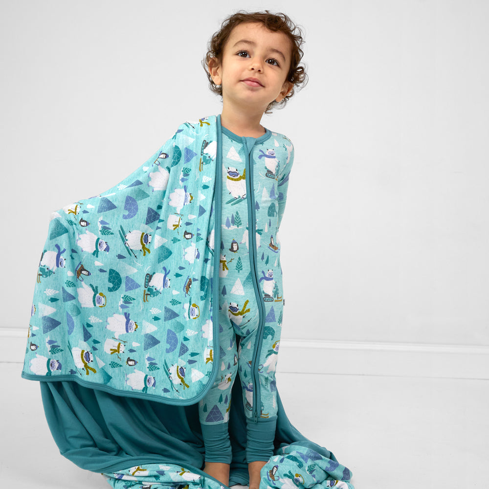 Image of a child wearing a Yeti Snow Day zippy and a matching cloud blanket