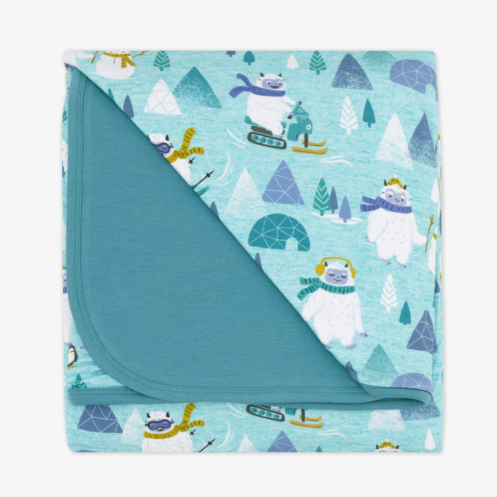 Flat lay image of a Yeti Snow Day cloud blanket showing the solid blue backing