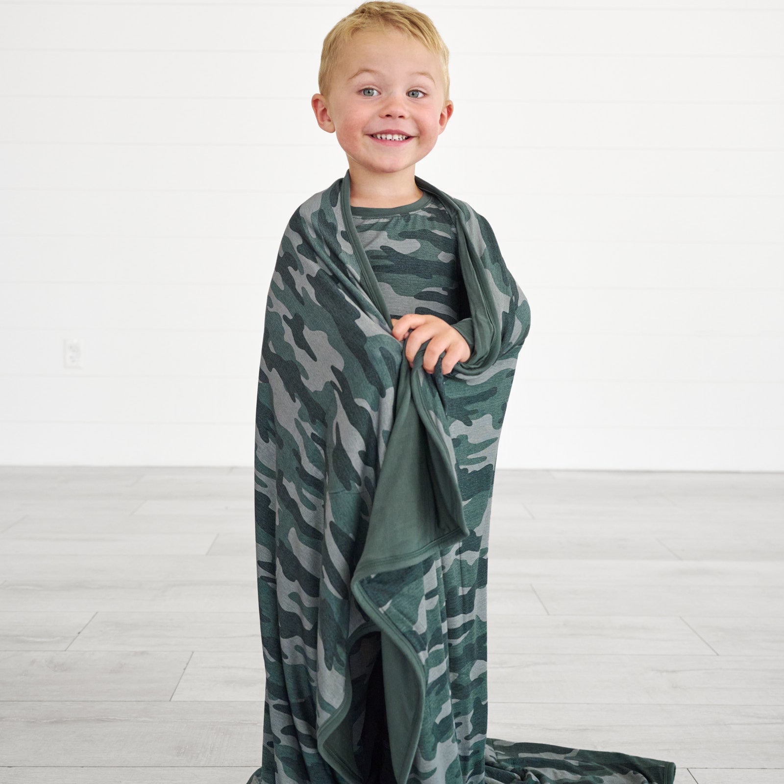 Boy standing while wrapped in the Vintage Camo Infant Gown