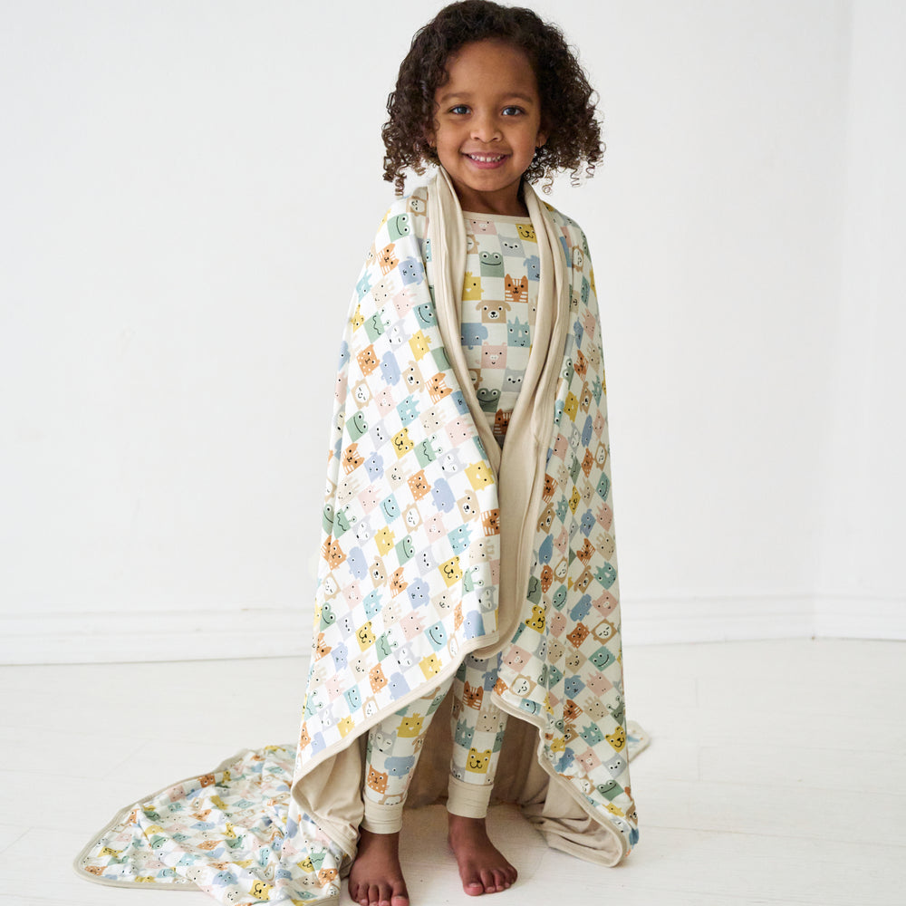 Child wrapped up in a Check Mates large cloud blanket and wearing matching pajamas