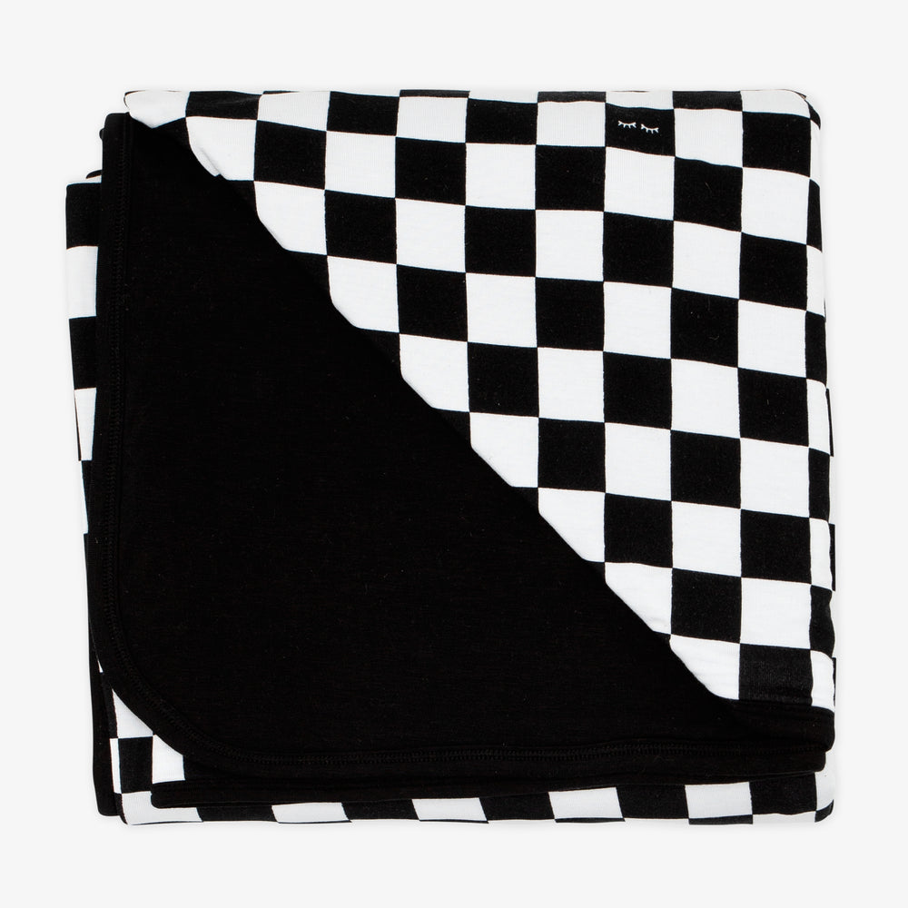 Flat lay image of a Cool Checks blanket showing the solid black backing