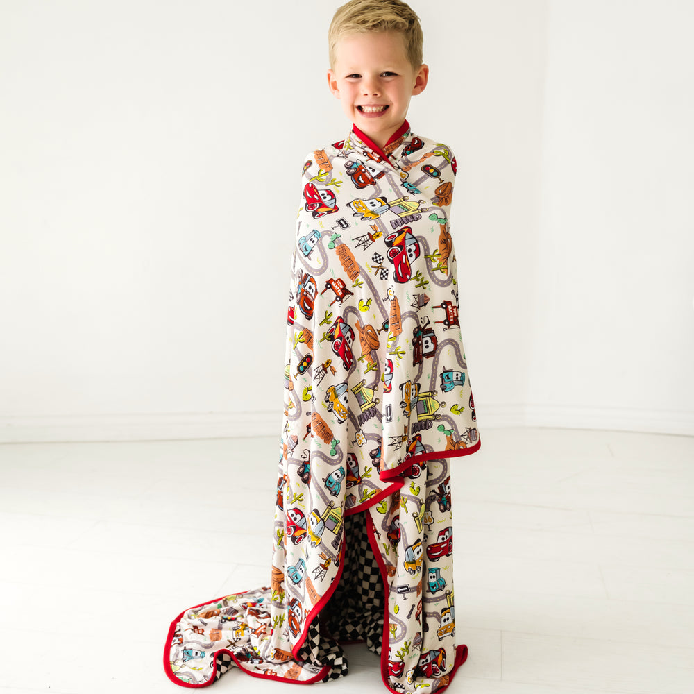 Child wrapped up wearing a Radiator Springs cloud blanket