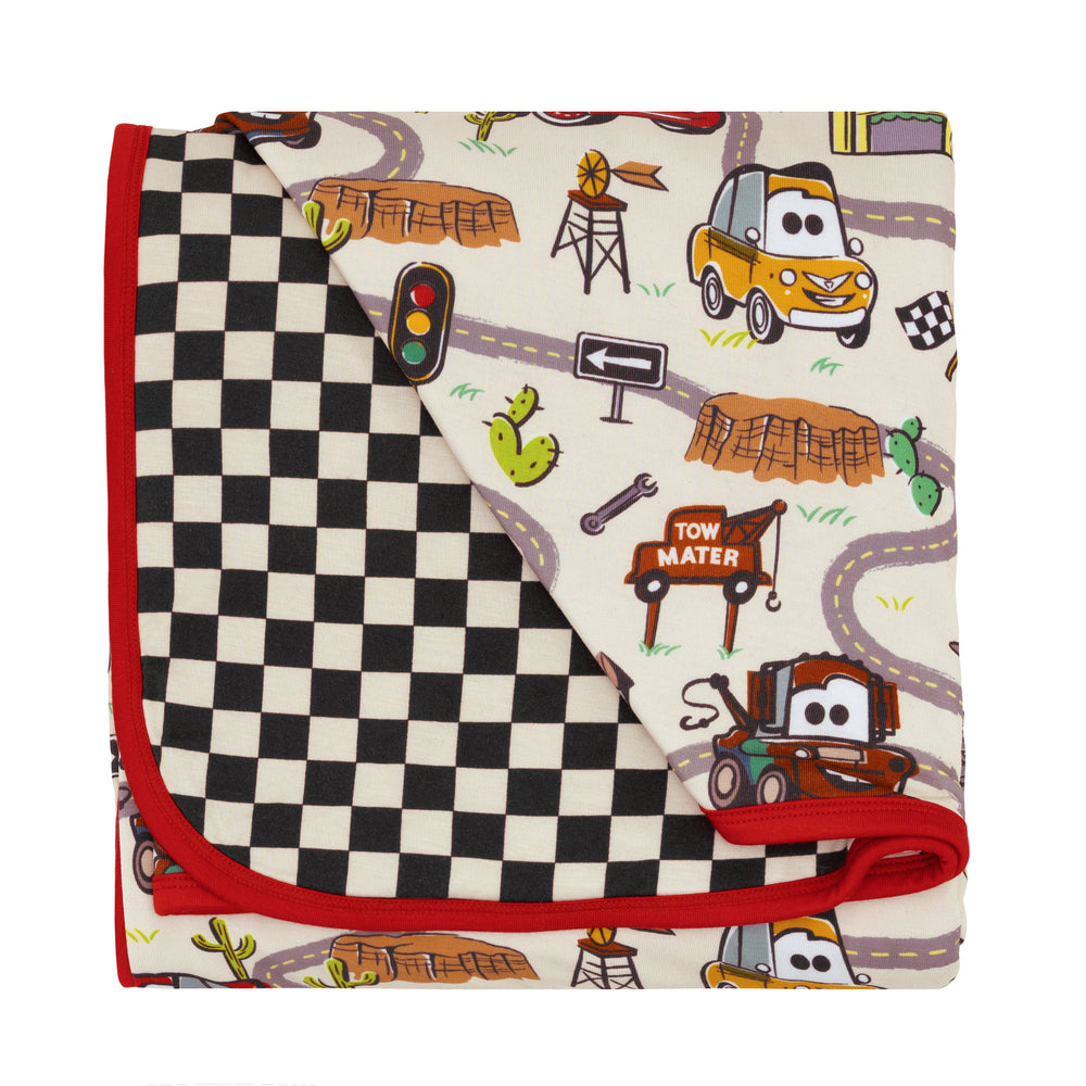 Flat lay image of a Radiator Springs cloud blanket showing the racing checks backing