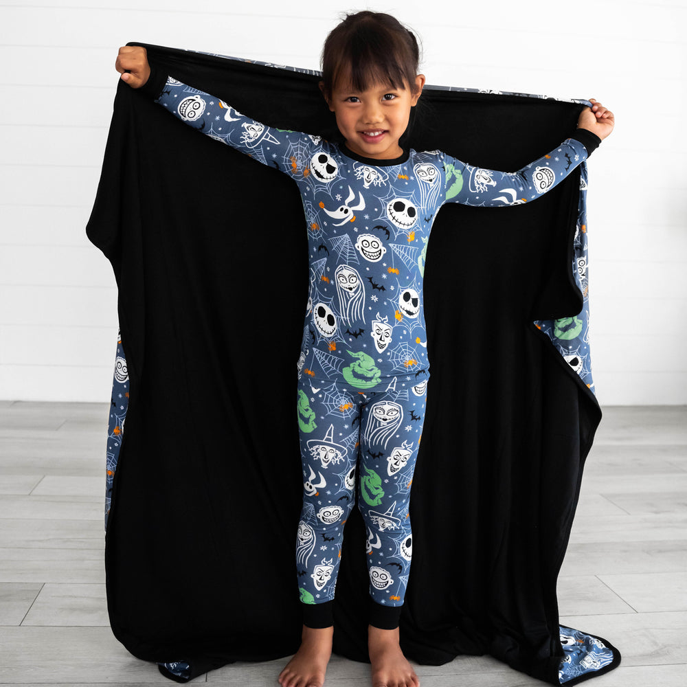 Girl posing with the Disney Jack & Crew Large Cloud Blanket®, displaying the inside color, which is black.