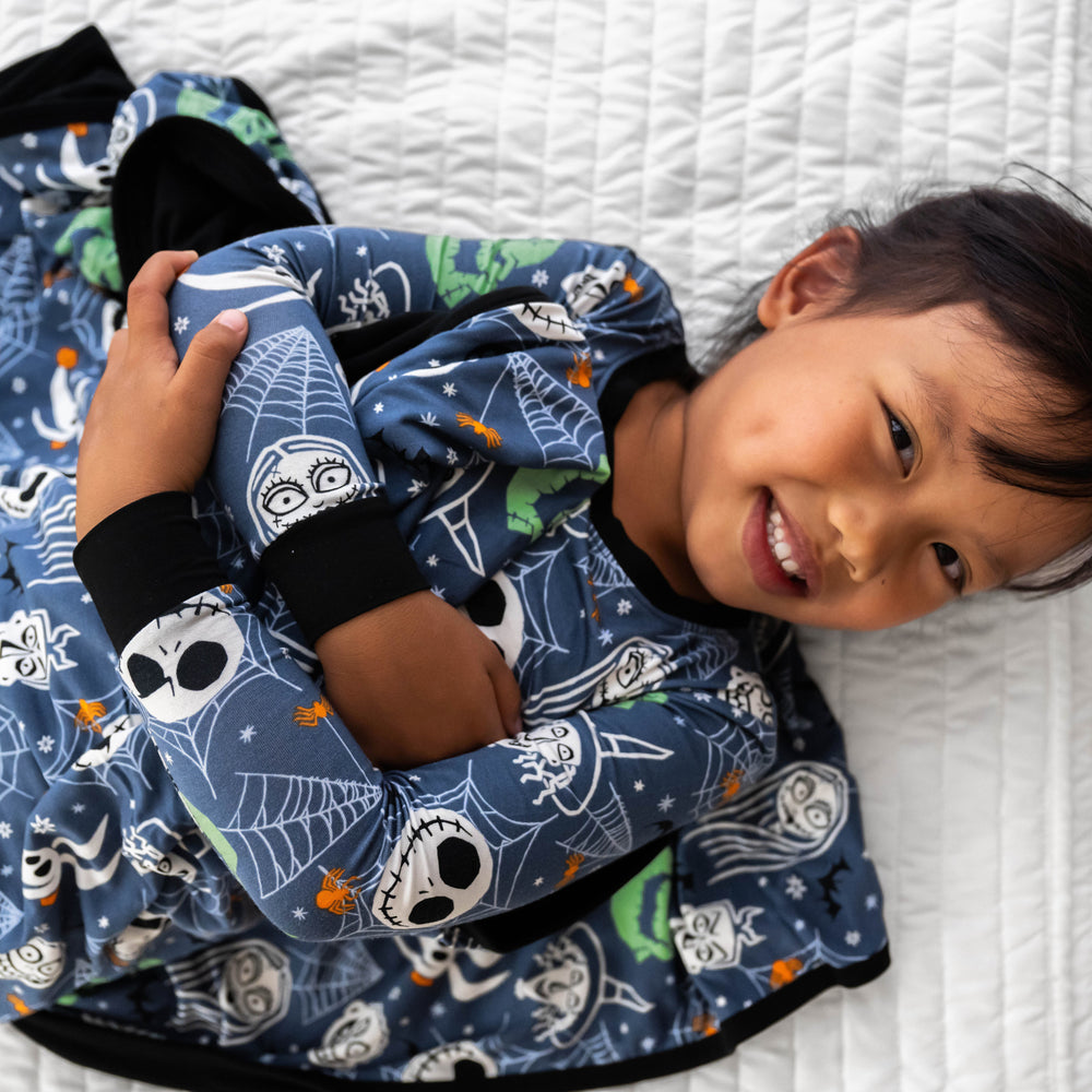 Top view close up image of girl laying down wrapped in the Disney Jack & Crew Large Cloud Blanket®