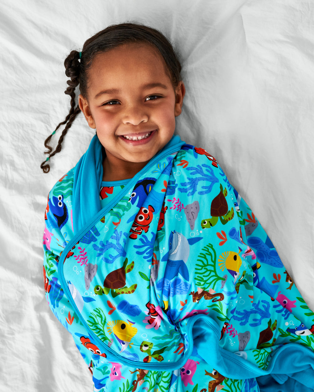 Ariel view of child wrapped in the Disney Nemo's Reef Large Cloud Blanket®