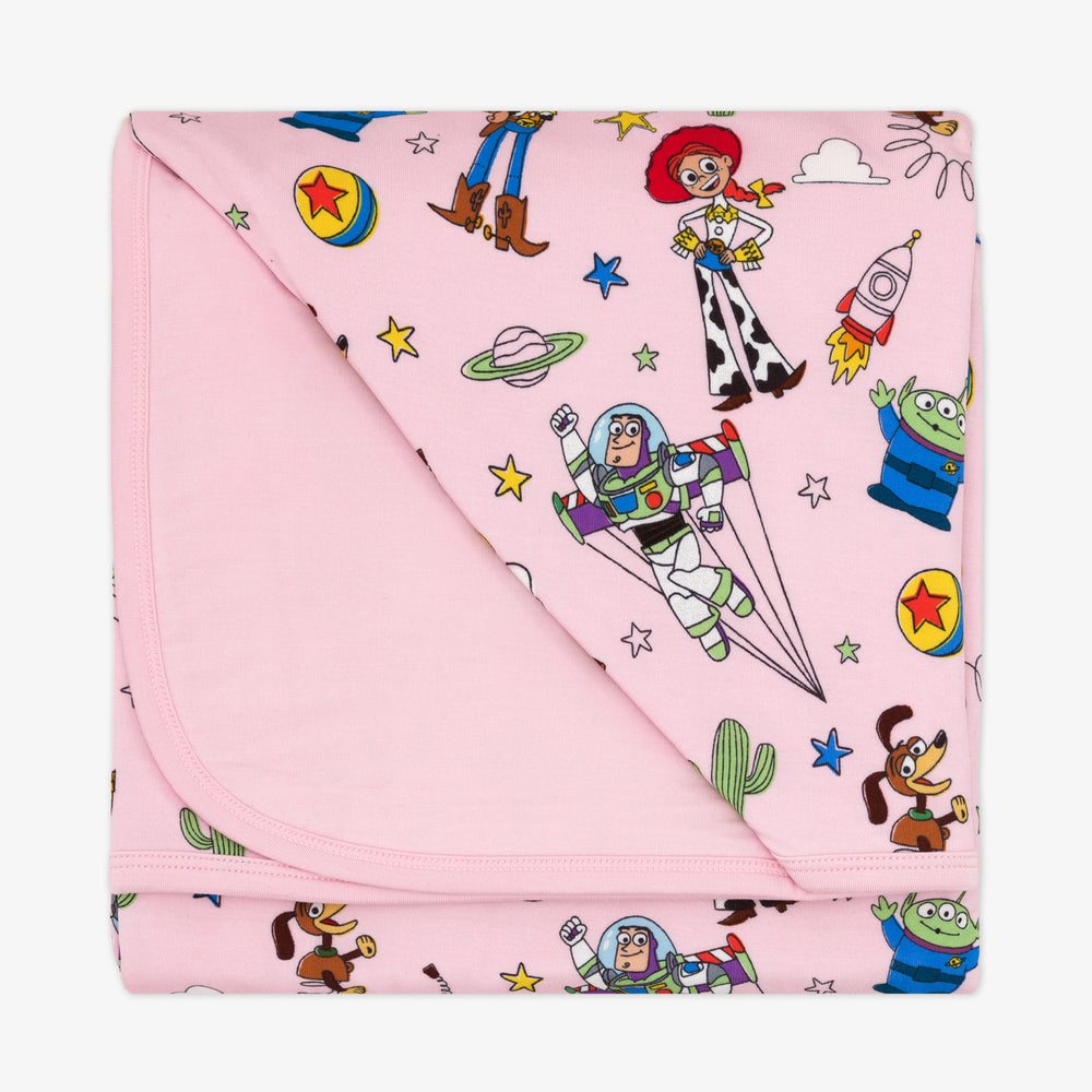 Flat lay image of a Pink Toy Story Stars cloud blanket showing the pink backing