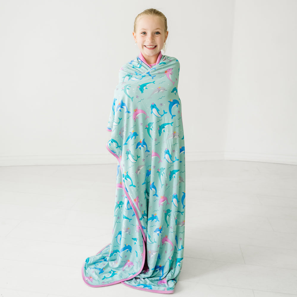 Child wrapped up in a Dolphin Dance large cloud blanket