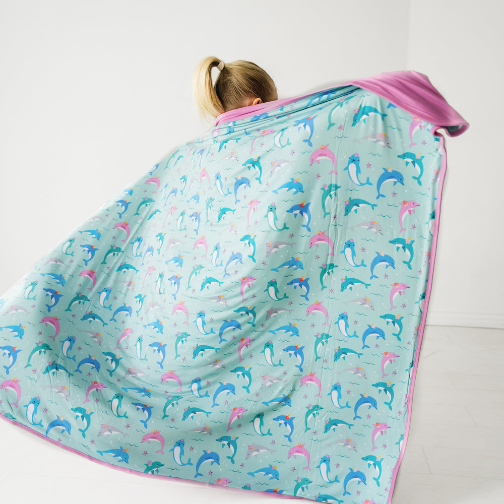 Back view image of a child holding out a Dolphin Dance large cloud blanket