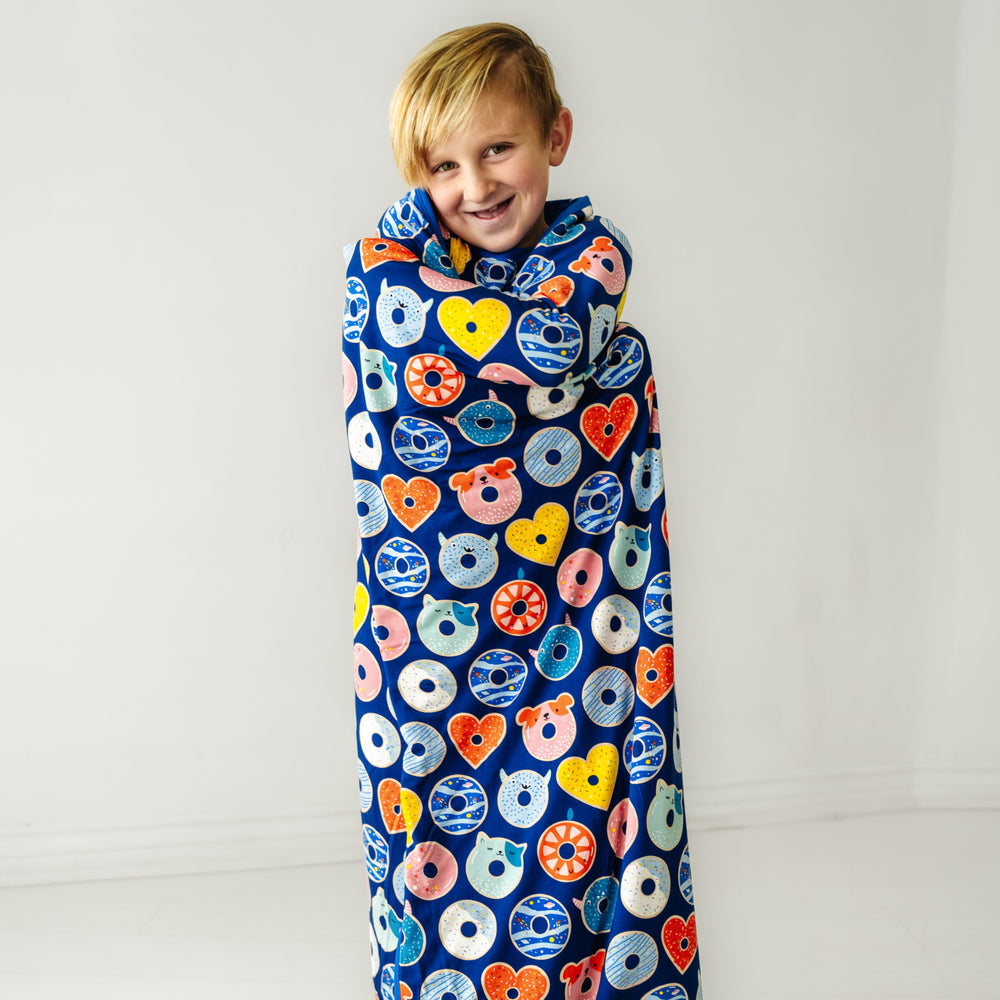 Child wrapped in a Blue Donut Dream cloud blanket