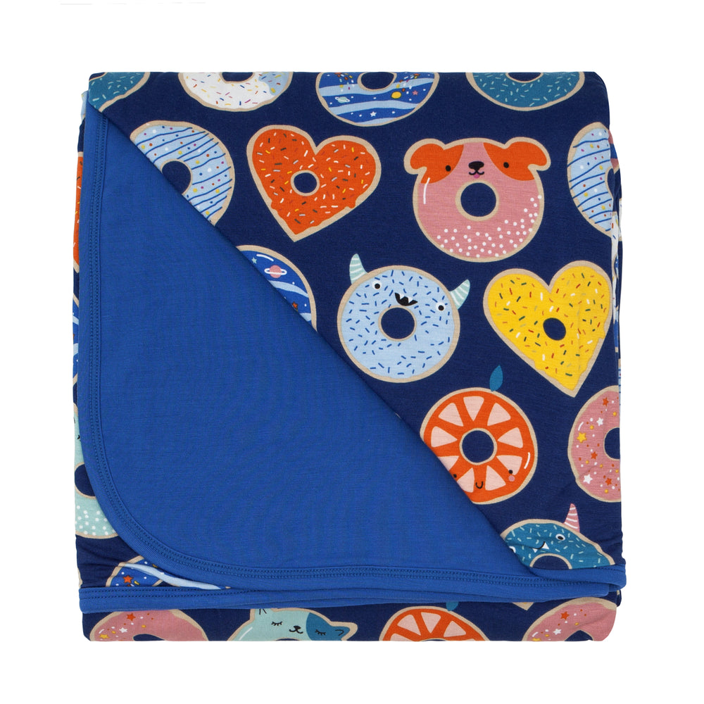 Click to see full screen - Flat lay image of a Blue Donut Dream large cloud blanket showing the solid blue backing