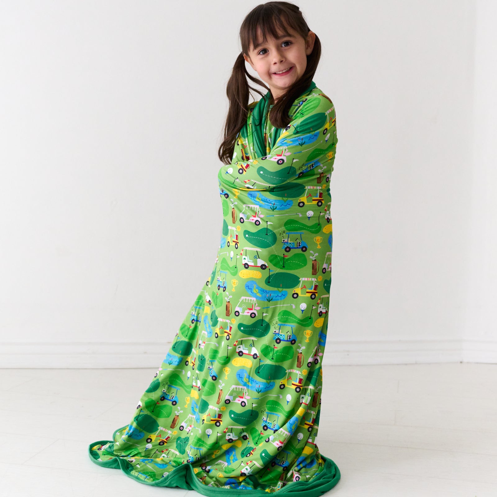 Child wrapped up in a Fairway Fun large cloud blanket