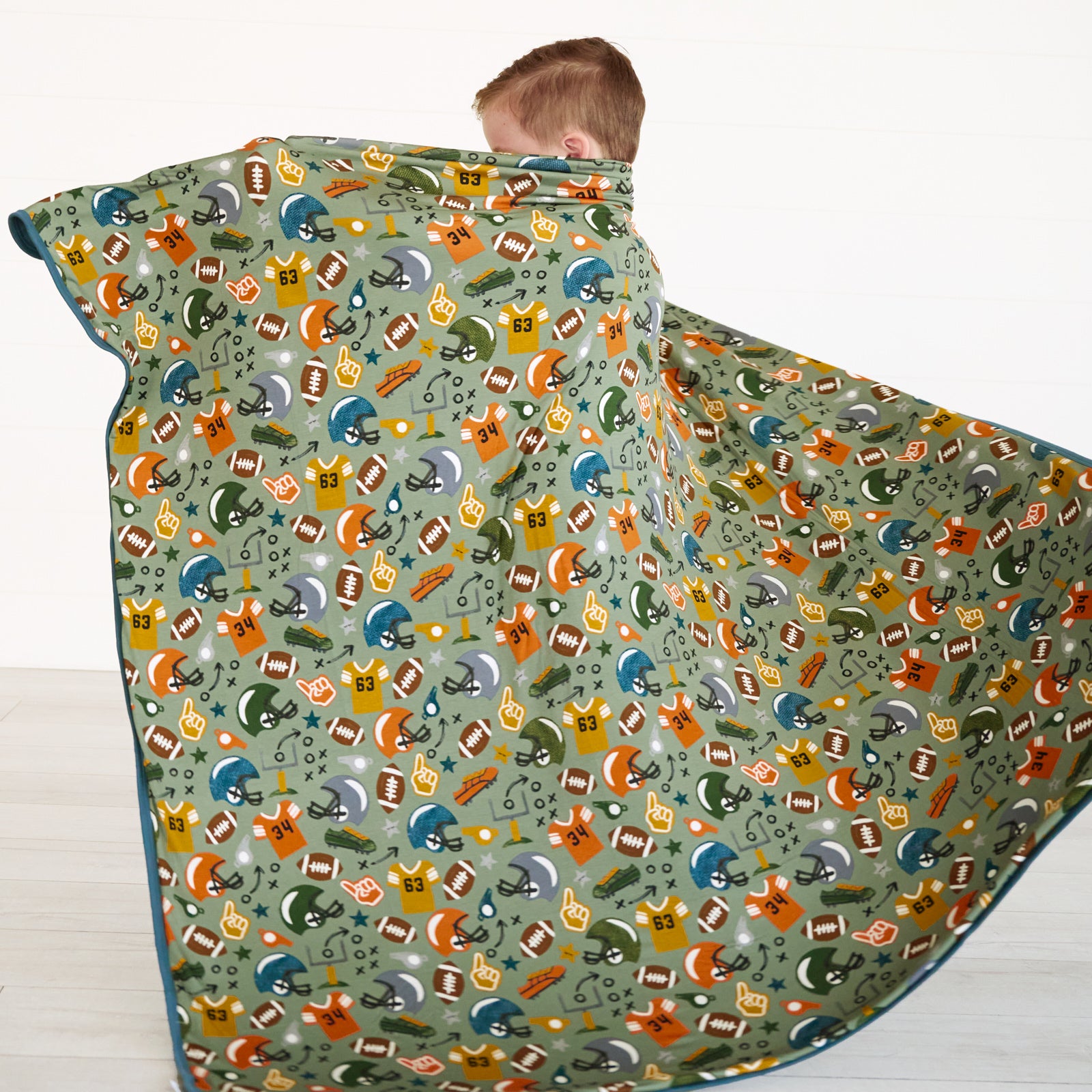 Image of boy wrapping himself in the Touchdown Time Large Cloud Blanket®