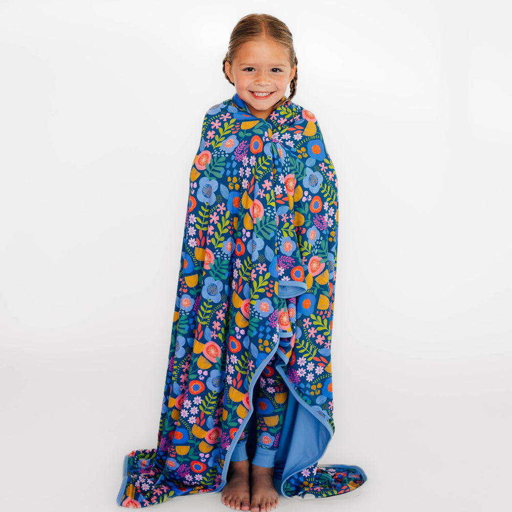 Girl wearing the Folk Floral Large Cloud Blanket® around her
