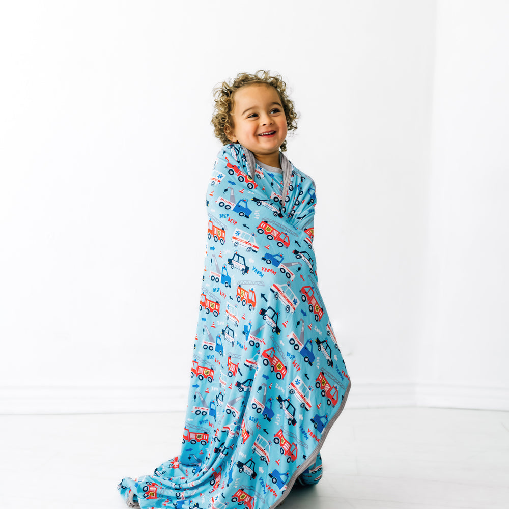 Child wrapped up in a To The Rescue large cloud blanket