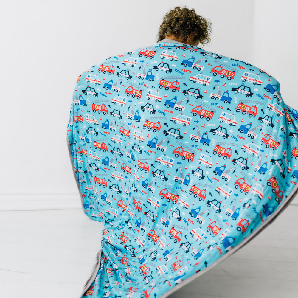 Back view of a child holding up a To The Rescue large cloud blanket