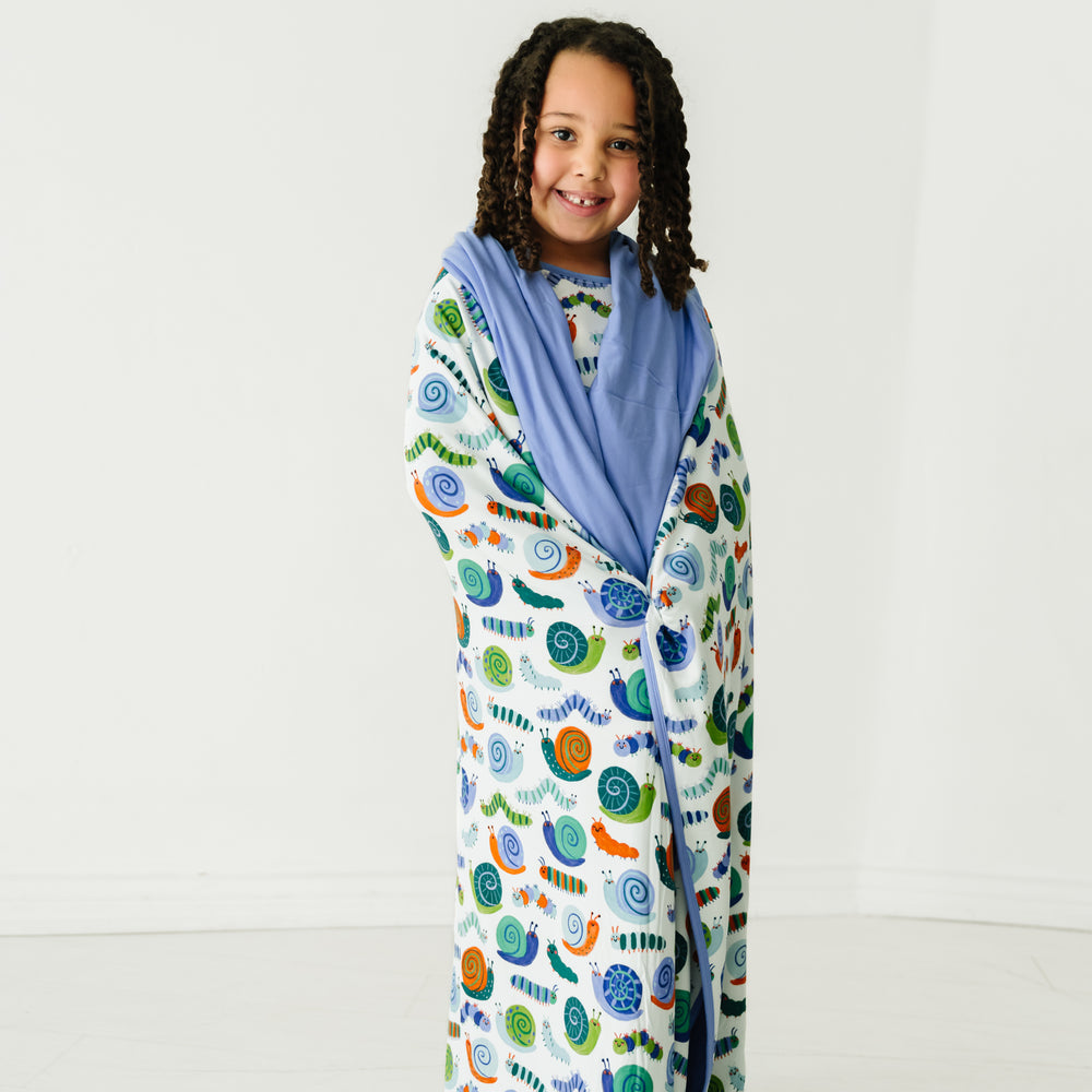 Child wrapped up in an Inchin' Along large cloud blanket