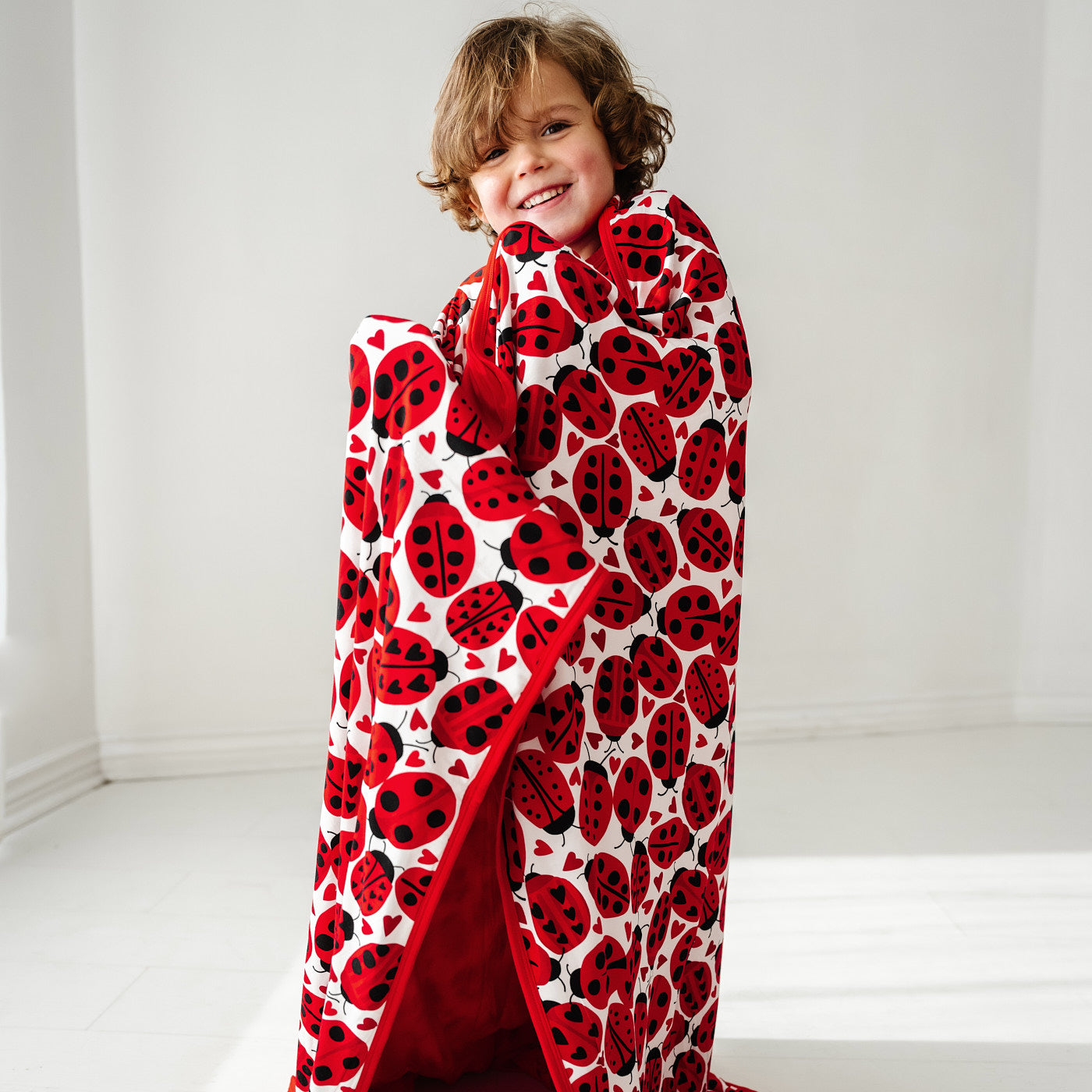 Alternate image of a child wrapped up in a Love Bug printed large cloud blanket