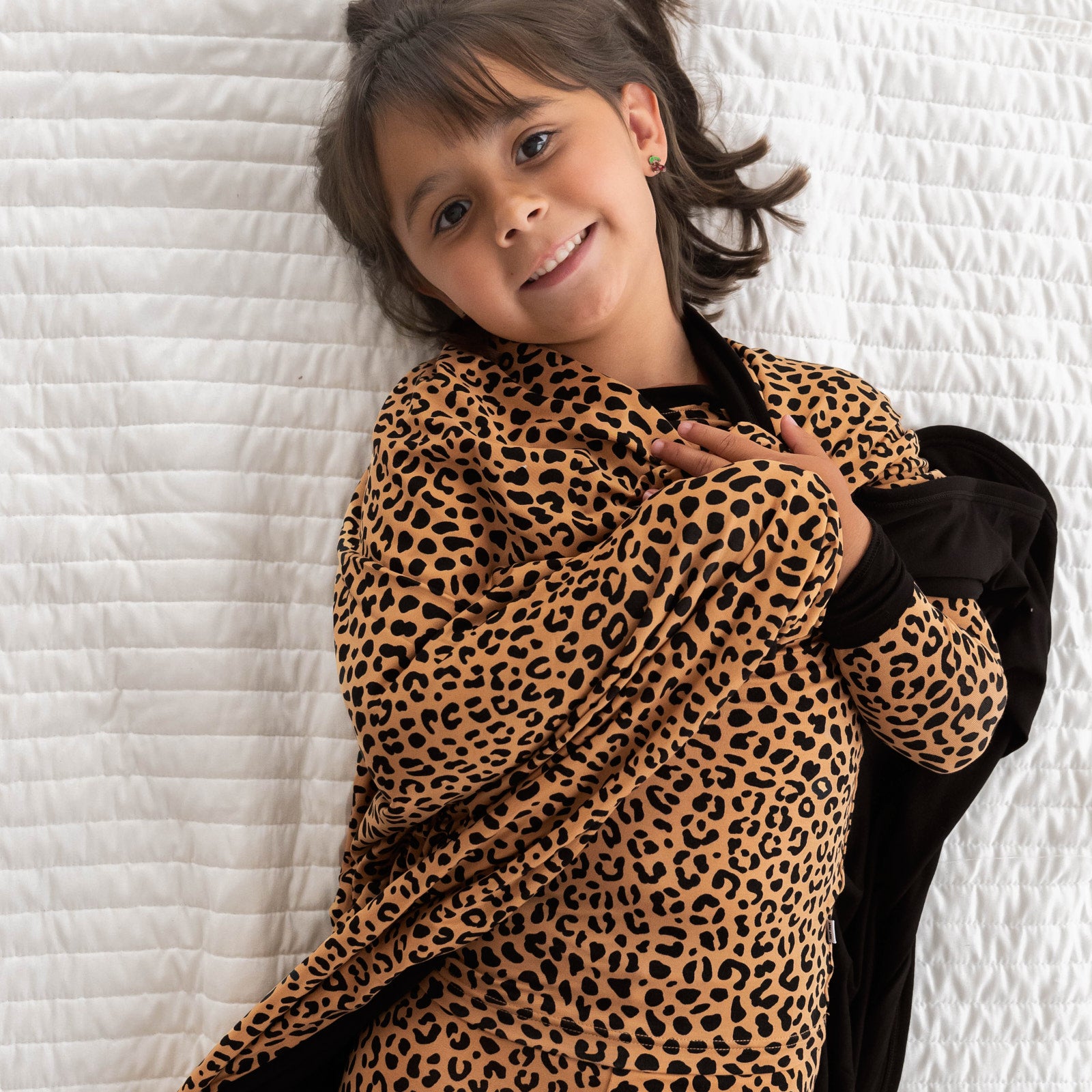 Top view image of girl laying down while wrapped in the Classic Leopard Large Cloud Blanket®