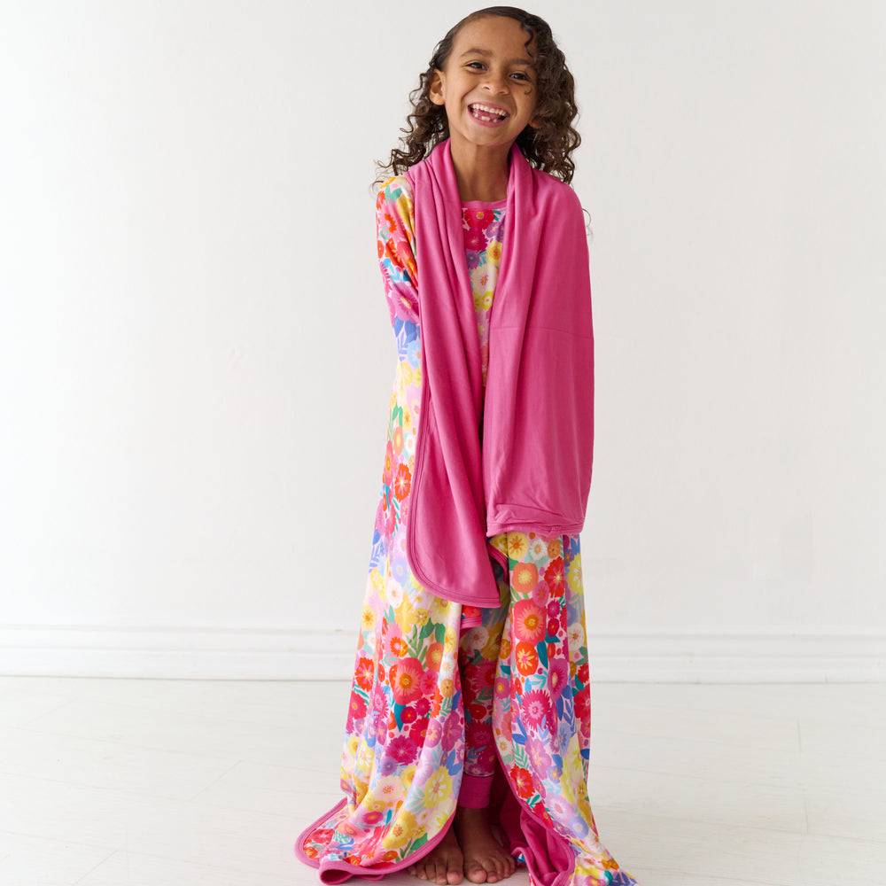 Child wrapped up in a Rainbow Blooms large cloud blanket