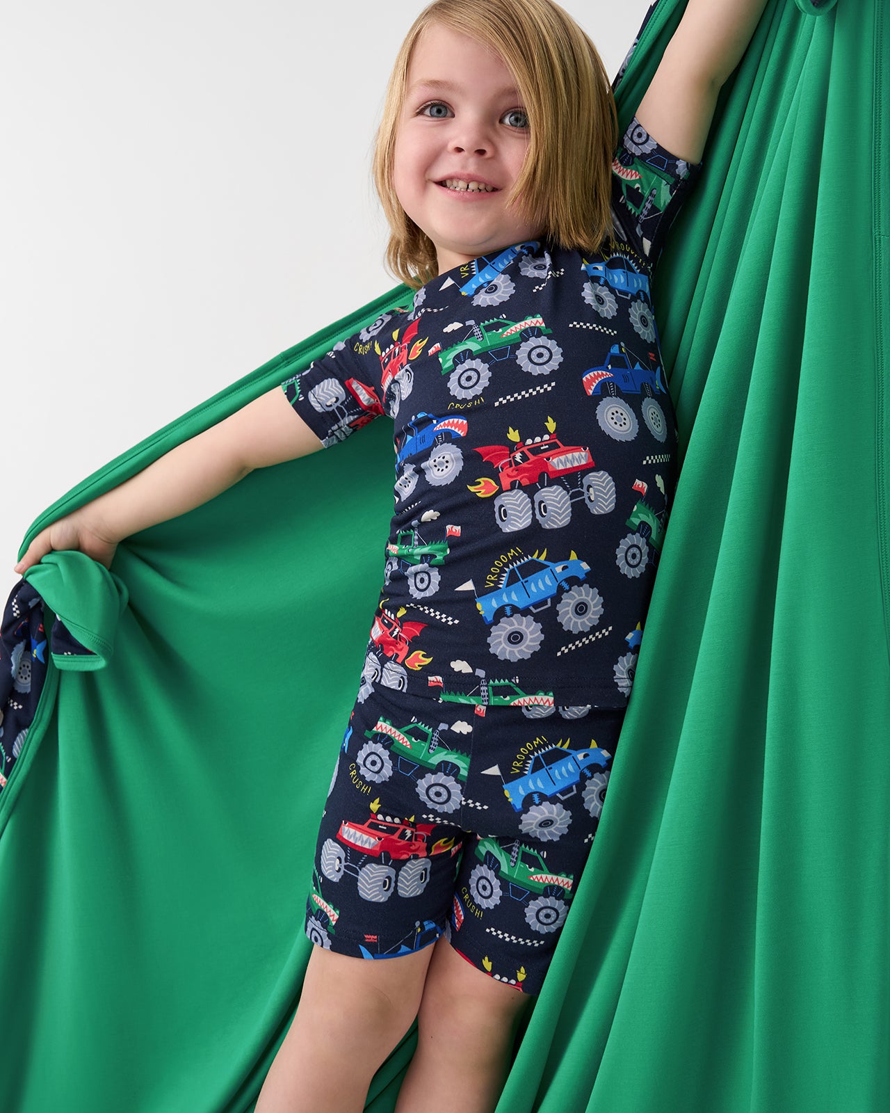 Child holding out the Monster Truck Madness Large Cloud Blanket® showing the solid green side