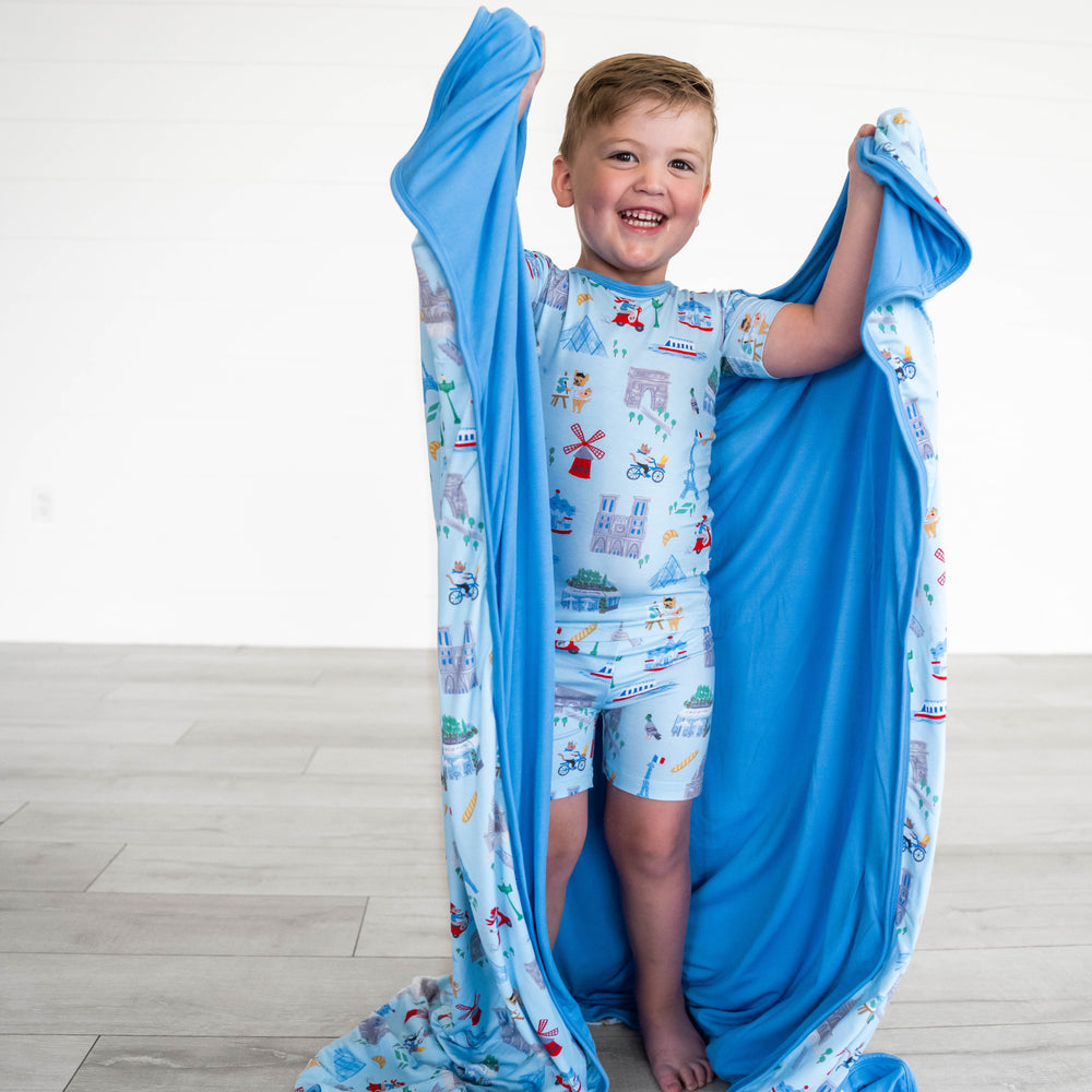 Alternative image of child holding up the Blue Weekend in Paris Large Cloud Blanket®