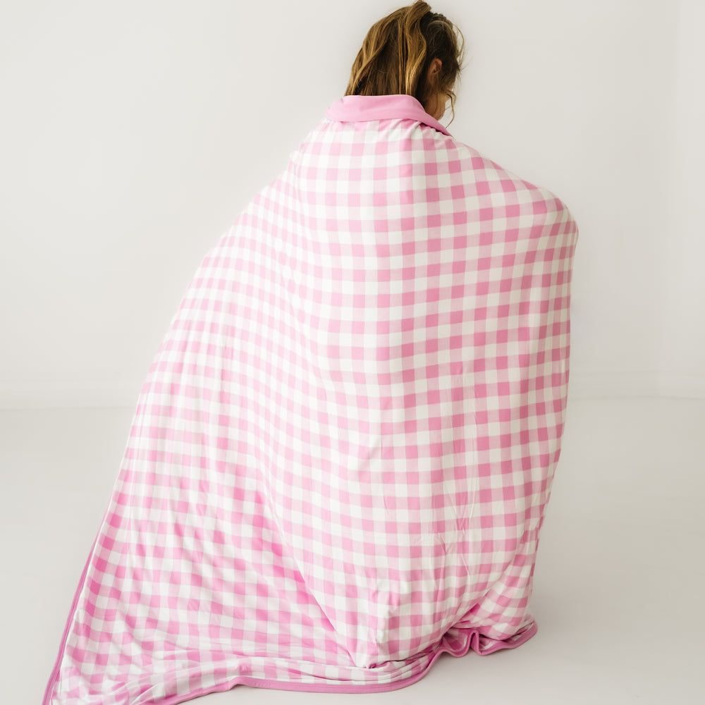 Click to see full screen - Back view of a child wearing a Pink Gingham cloud blanket over her shoulders