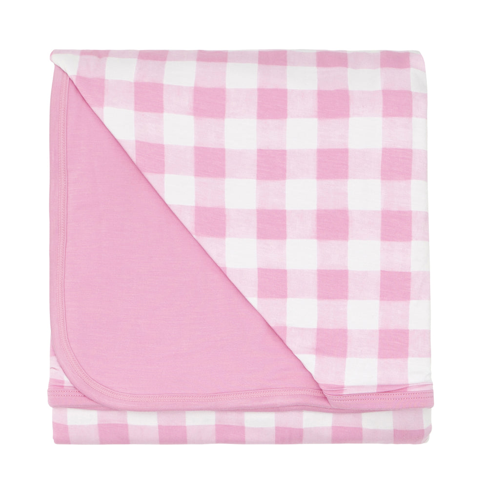 Click to see full screen - Flat lay image of a Pink Gingham large cloud blanket showing the solid pink backing