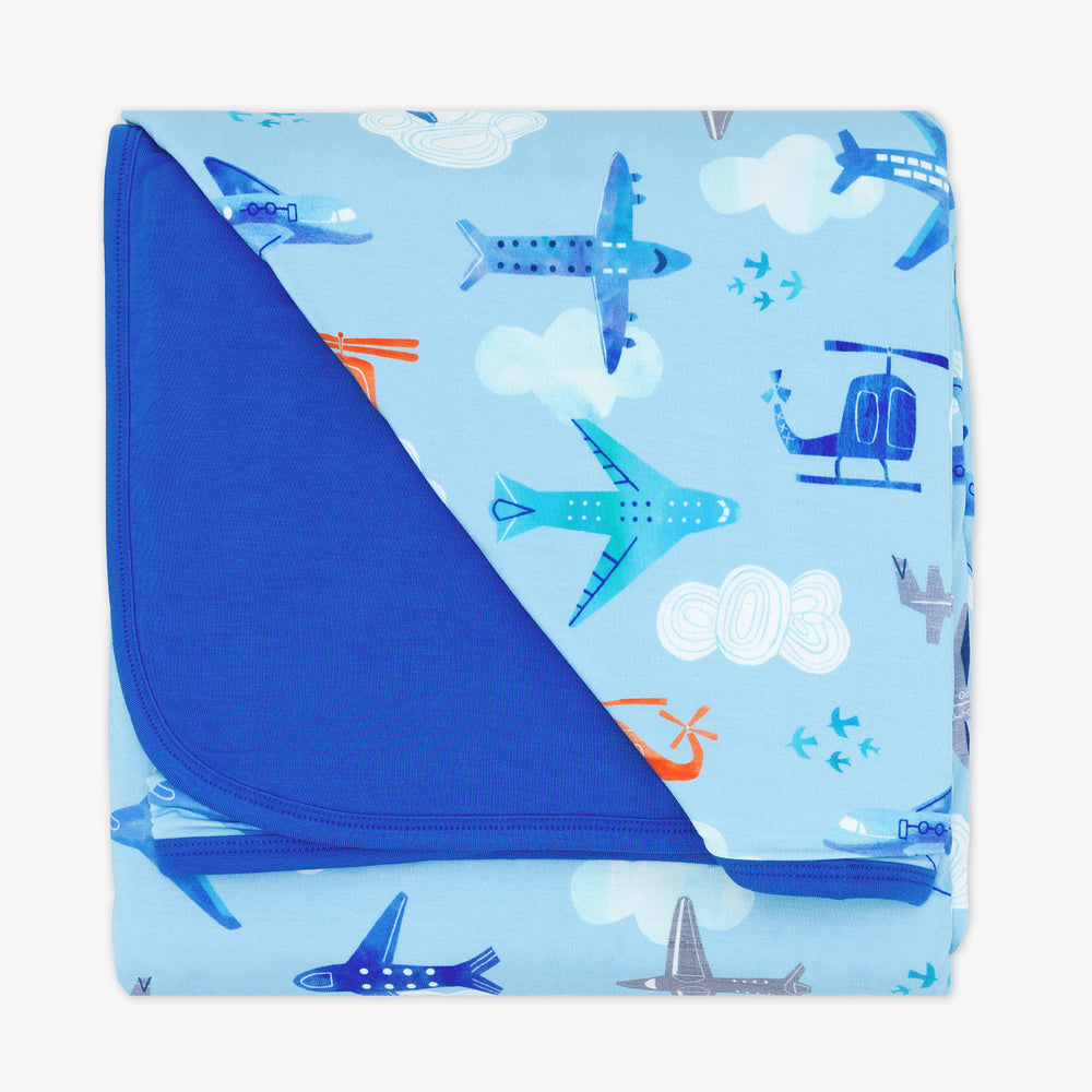 flat lay image of a lets fly cloud blanket showing the solid blue backing