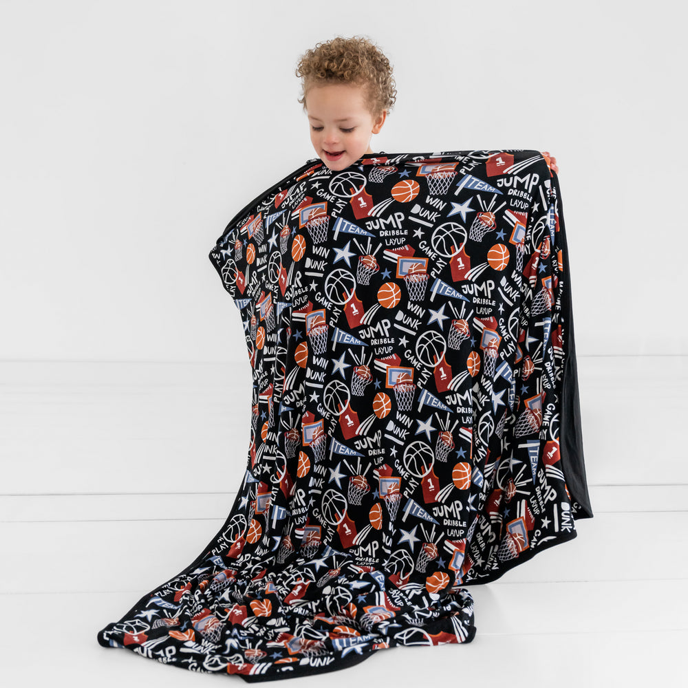 Child holding up the Black Slam Dunk Cloud blanket