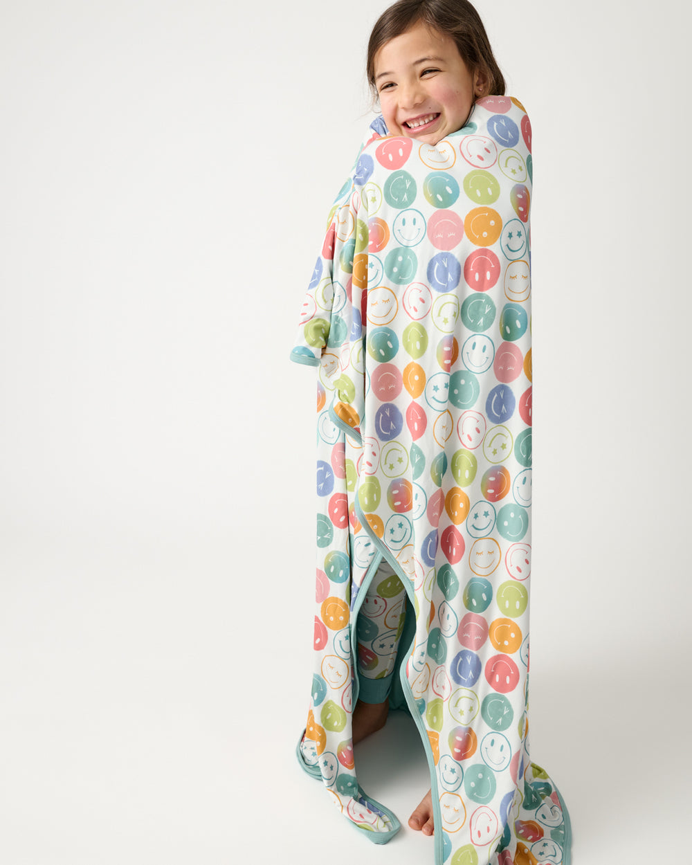 Standing girl wrapped in the Positive Vibes Large Cloud Blanket®
