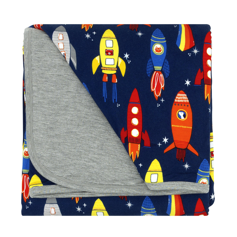 Flat lay image of a Navy Space Explorer cloud blanket showing the heather gray backing