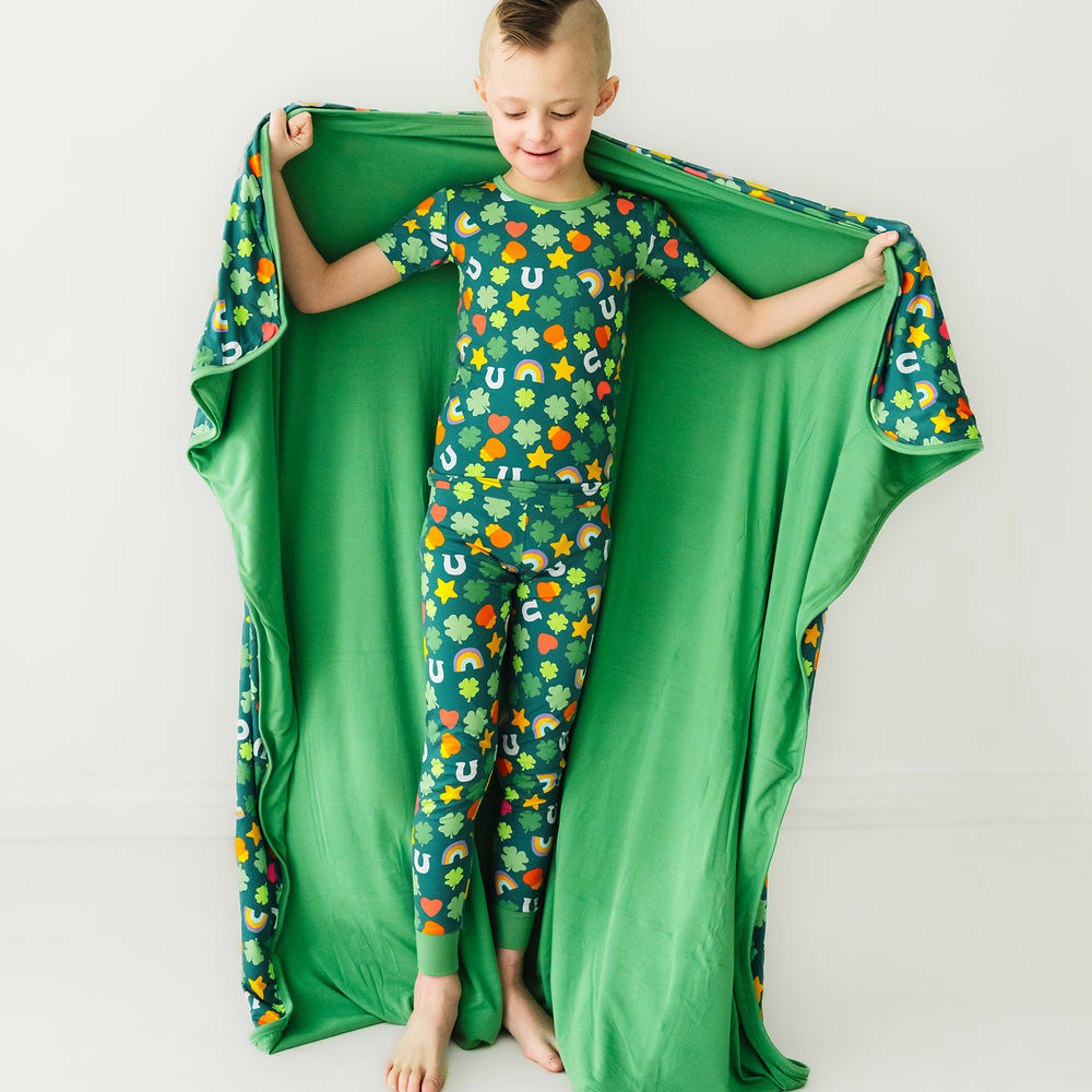 Child wearing a Lucky cloud blanket over his shoulders wearing a matching Lucky printed short sleeve two piece pajama set
