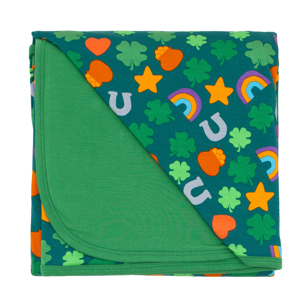 Flat lay image of Lucky cloud blanket showing the solid green backing