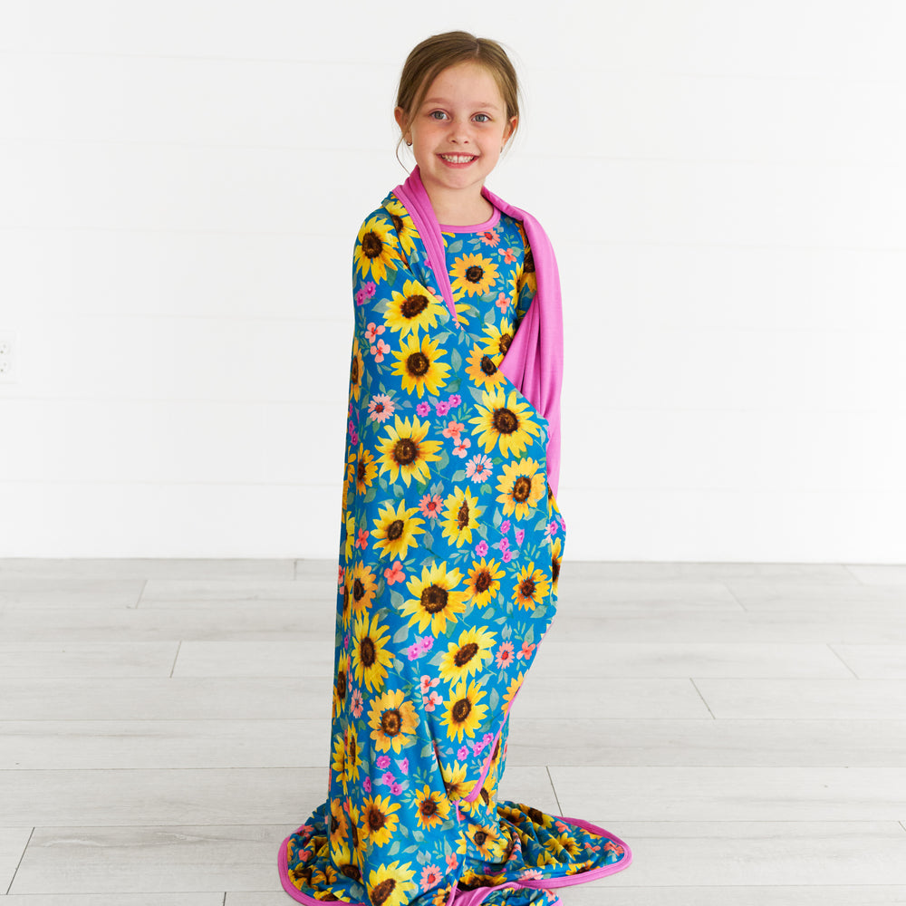 Image of girl wrapped in the Sunflower Fields Large Cloud Blanket®