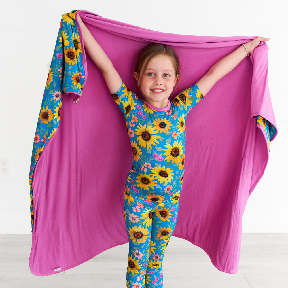 Girl posing with the Sunflower Fields Large Cloud Blanket®, displaying the inside of the blanket