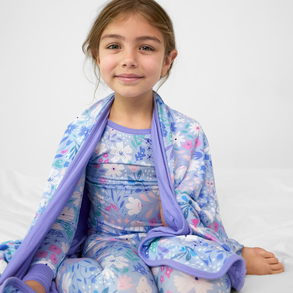 image of a Magical Meadow cloud blanket over the shoulders of a child wearing a matching two piece pj set