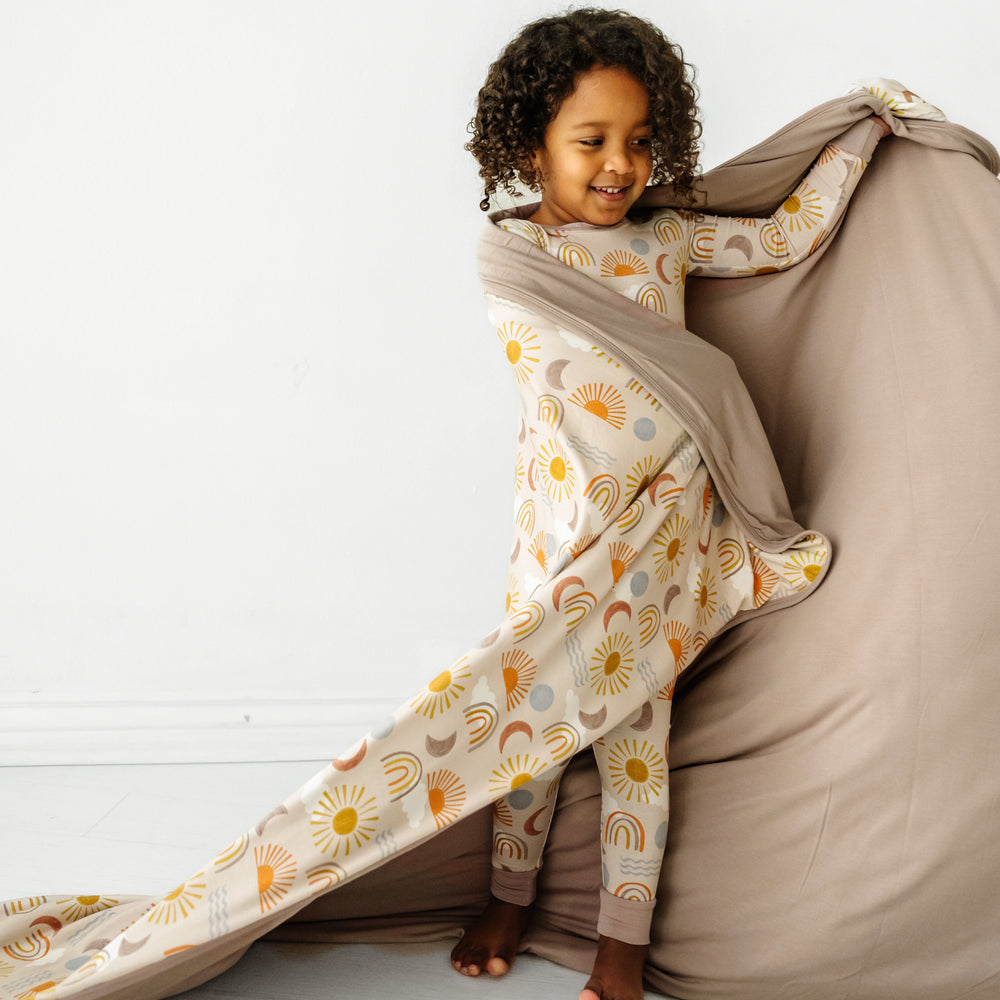 Alternate image of a child wearing Desert Sunrise two piece pjs pants with a matching printed large cloud blanket over her shoulders