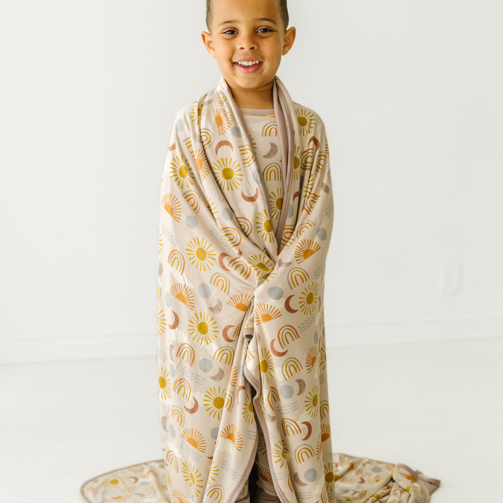 Child wrapped in a Desert Sunrise large cloud blanket