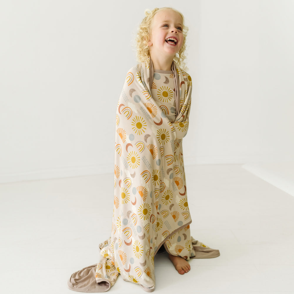 Alternate image of a child wrapped in a Desert Sunrise large cloud blanket