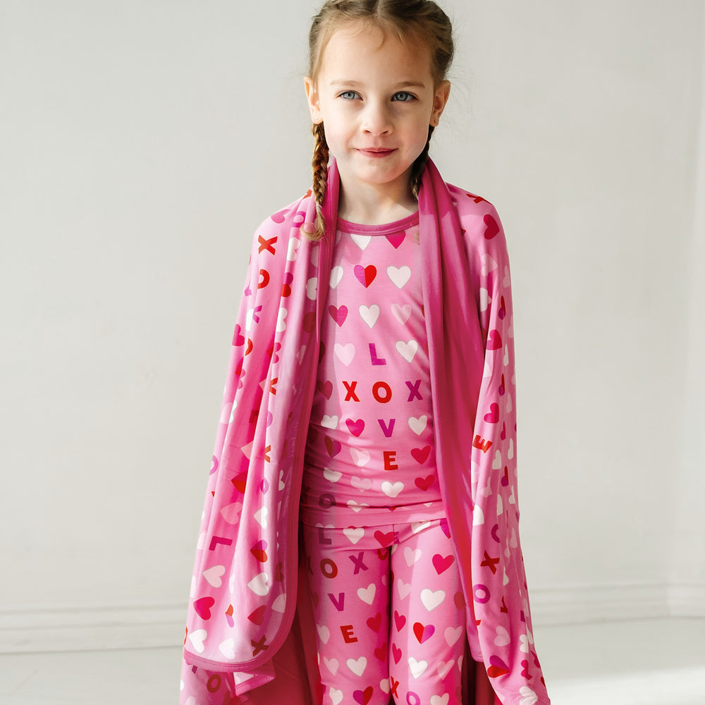 Click to see full screen - child wearing a Pink XOXO two piece pajama set wearing a matching large cloud blanket over their shoulders