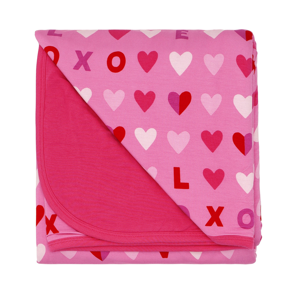 Click to see full screen - Flat lay image of a Pink XOXO large cloud blanket showing the solid pink backing
