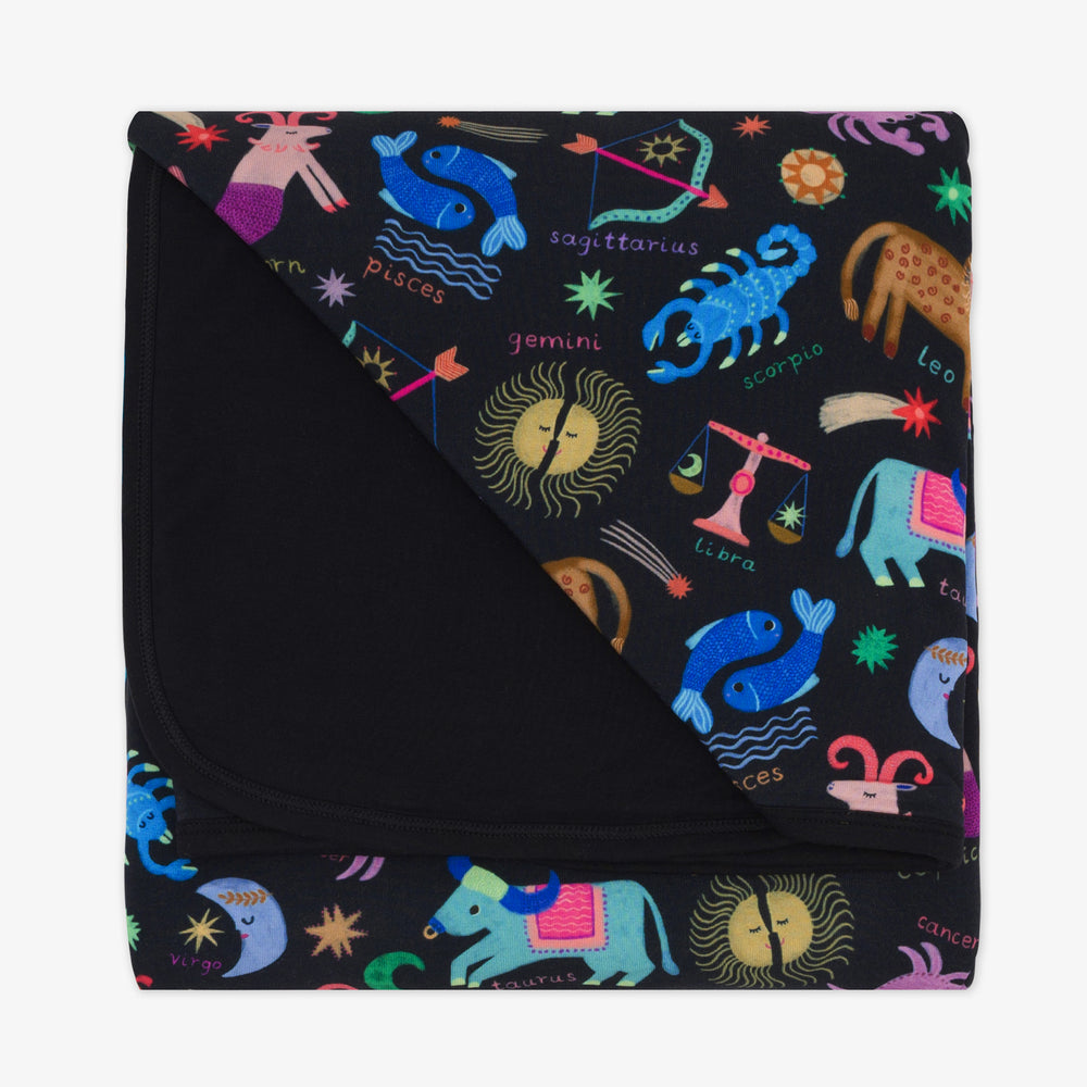 Flat lay image of a Star Signs Blanket showing the solid black backing