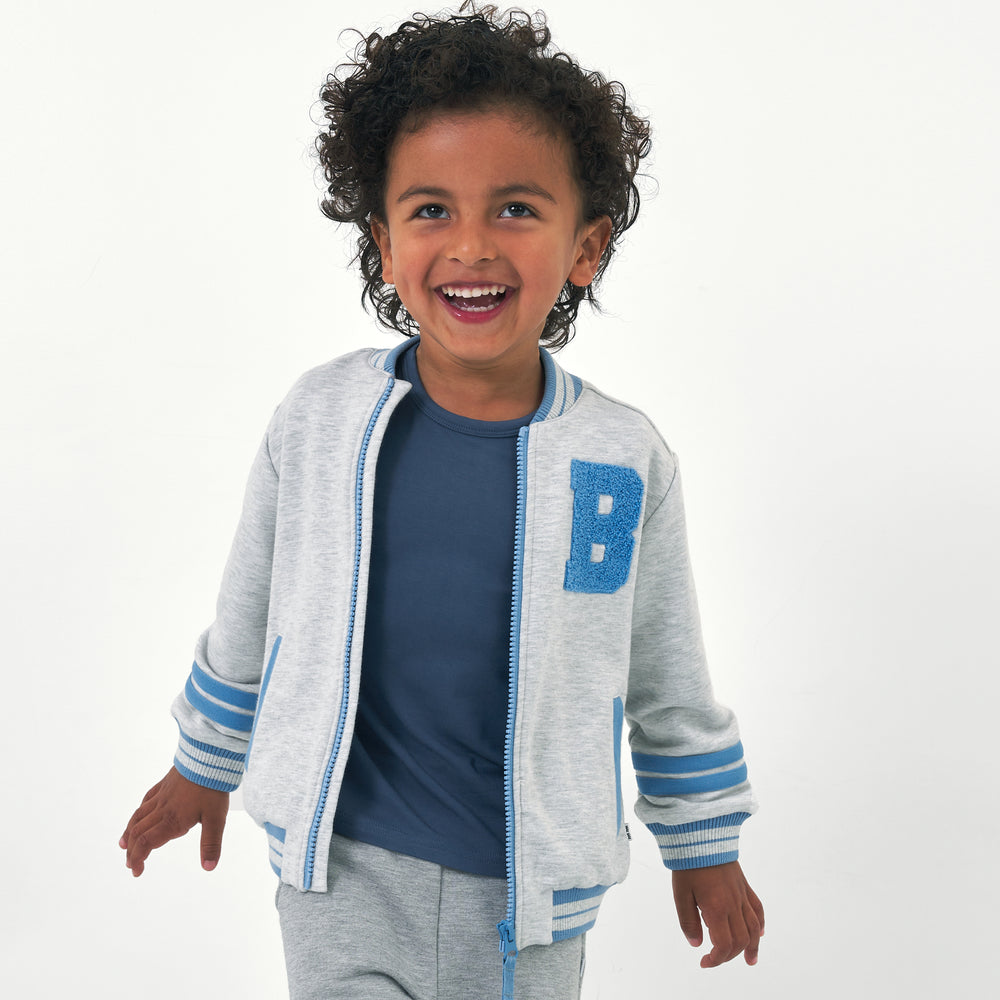 Child wearing a Bluey gray bomber jacket and coordinating outfit