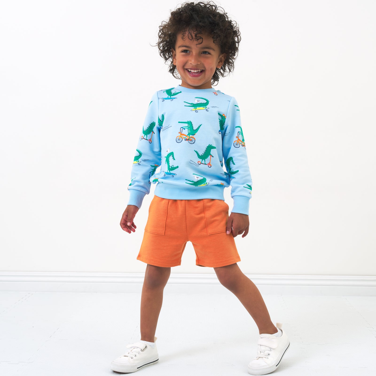 Child wearing Rust Orange shorts and coordinating crewneck sweatshirt