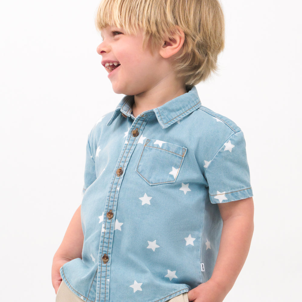 Close up image of a child wearing a Denim Stars button down polo