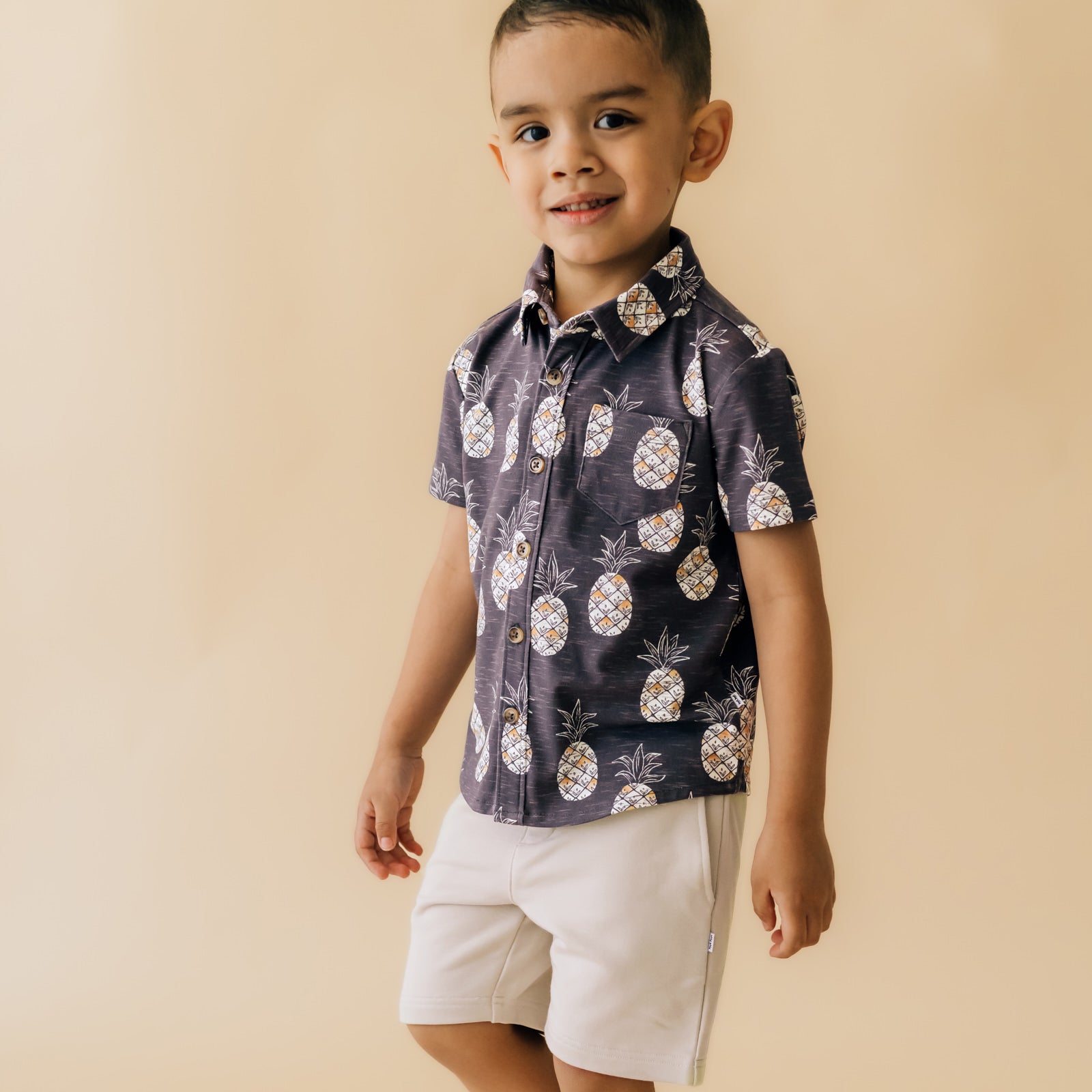 Child wearing Bone Drawstring Shorts paired with a Sweet Paradise button down shirt
