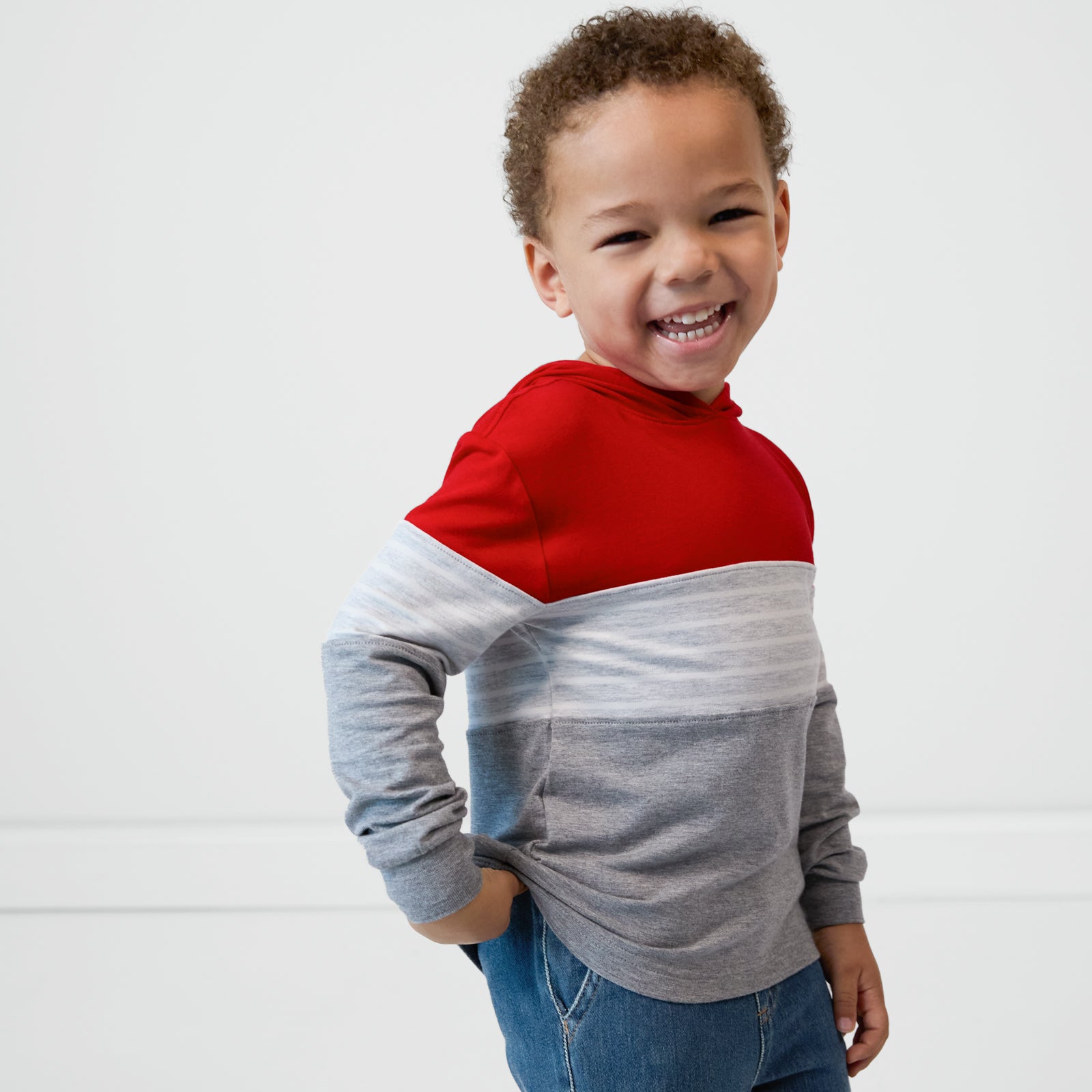 Laughing child wearing a Candy Red Colorblock Hooded Tee