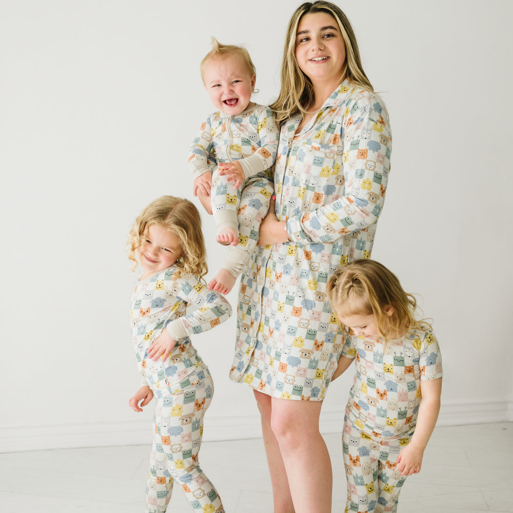 Woman and her three children wearing matching Check Mates printed pjs. Mom is wearing a Check Mates women's sleep shirt, her kids are wearing two piece and zippy styles.