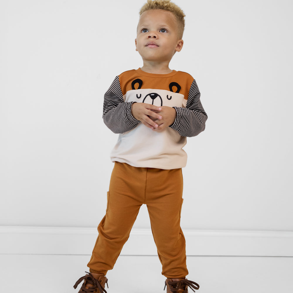 Child wearing Golden Brown cinched joggers paired with a coordinating crewneck sweatshirt